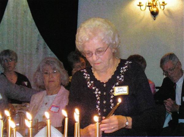 Kathy Leinauer Lenschow lighting candle at memorial service.